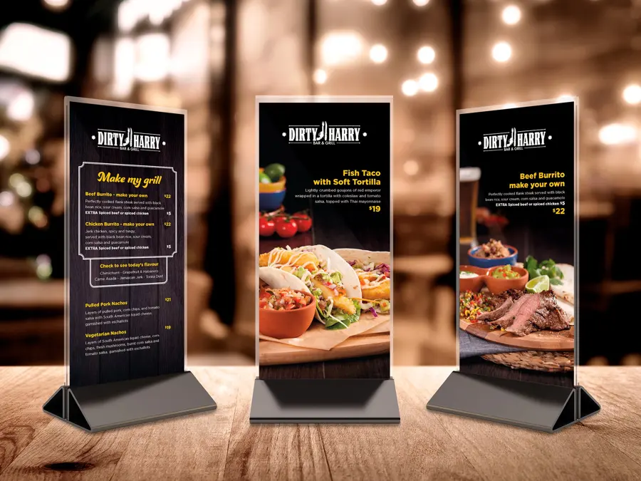 Three illuminated menu totems standing in a dark restaurant
