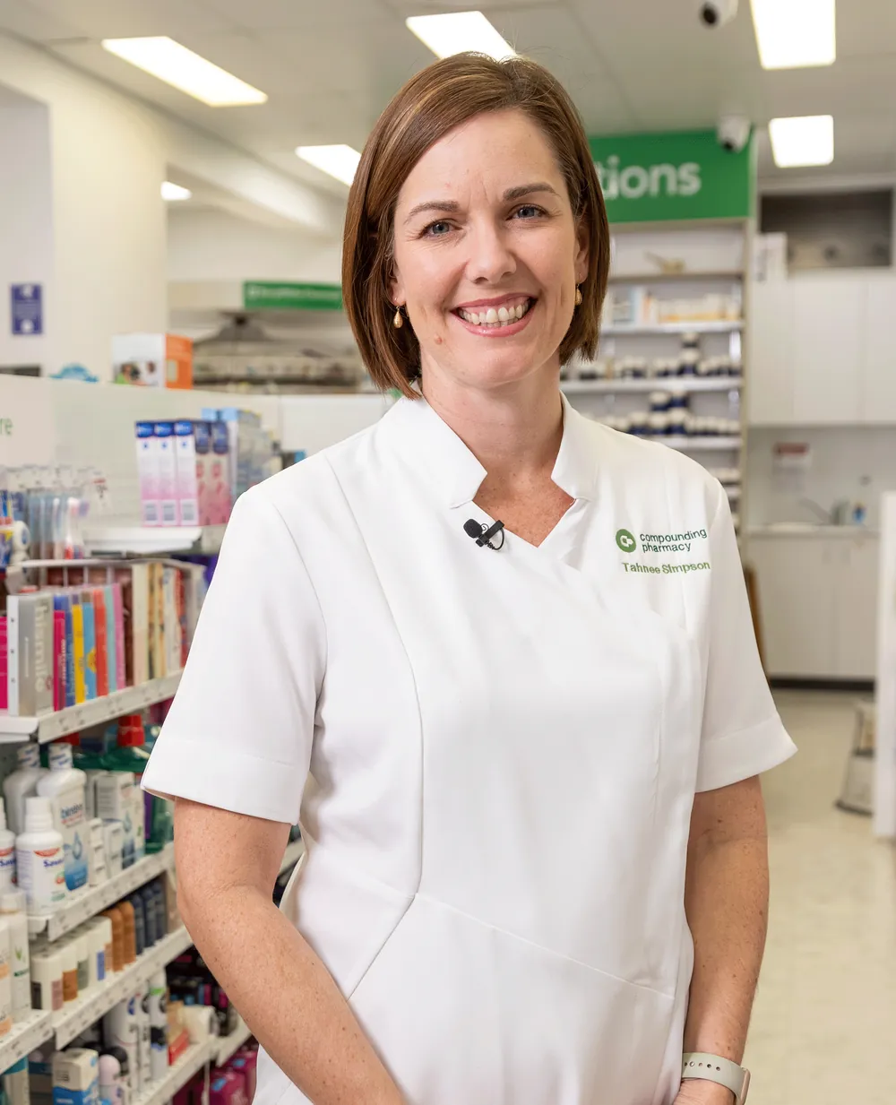 Pharmacist Tahnee Simpson smiling in the aisle of her compounding pharmacy
