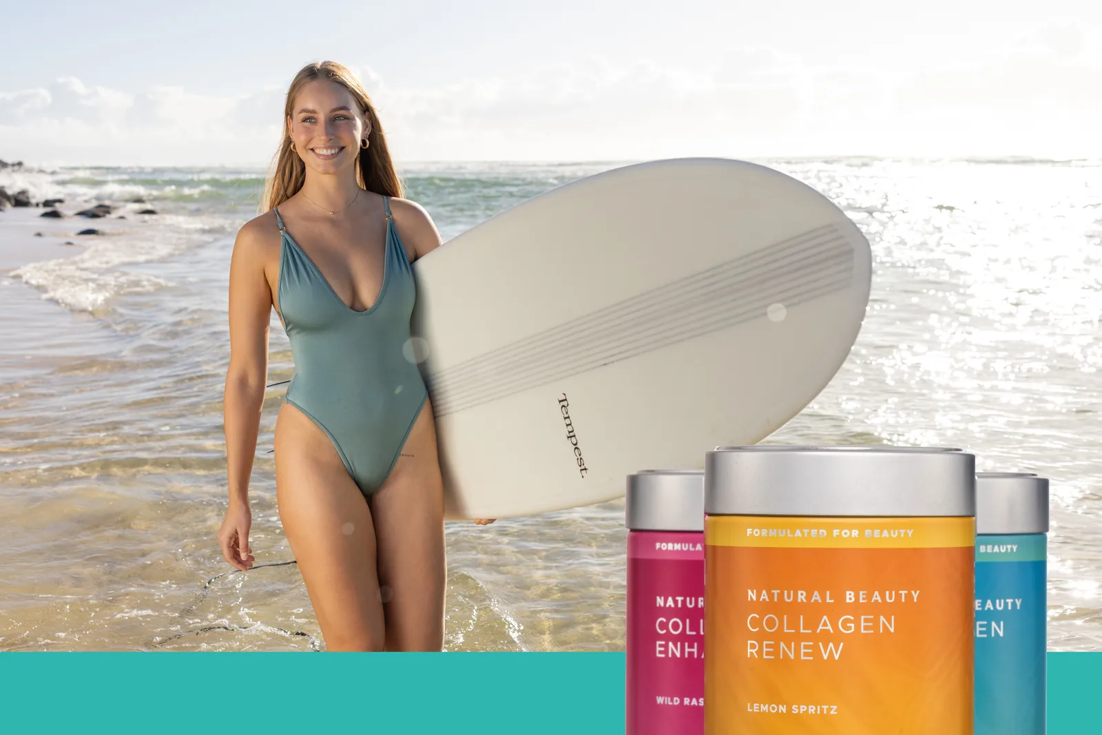 A smiling woman carrying a surfboard out of the sea, with three Natural Beauty collagen tins in the foreground