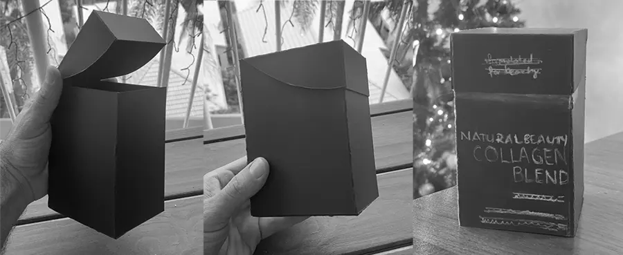 Black prototype boxes being folded and tested by hand