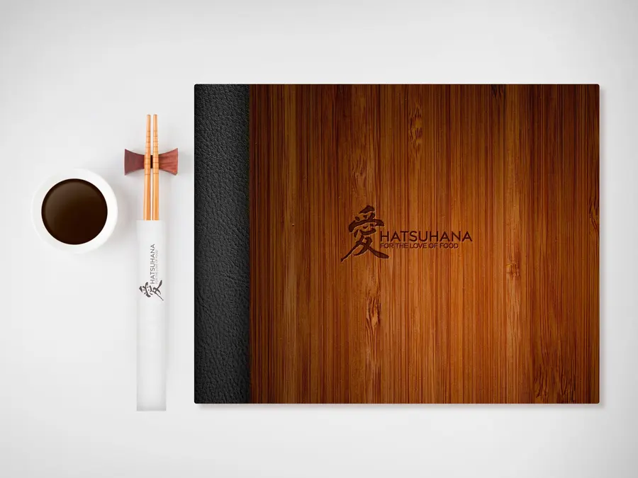 A timber menu cover with chopsticks and a coffee cup