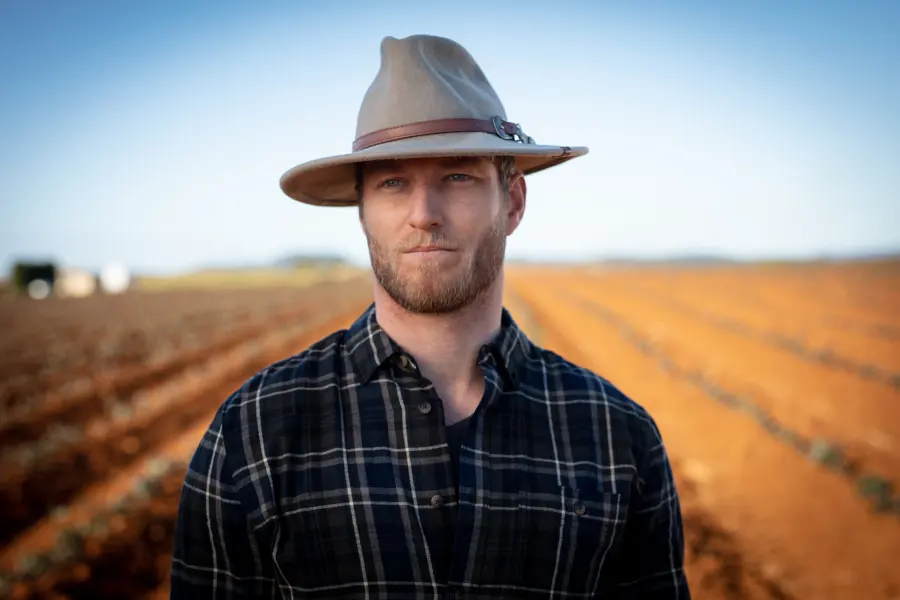 Portrait of a farmer in a hat in his field