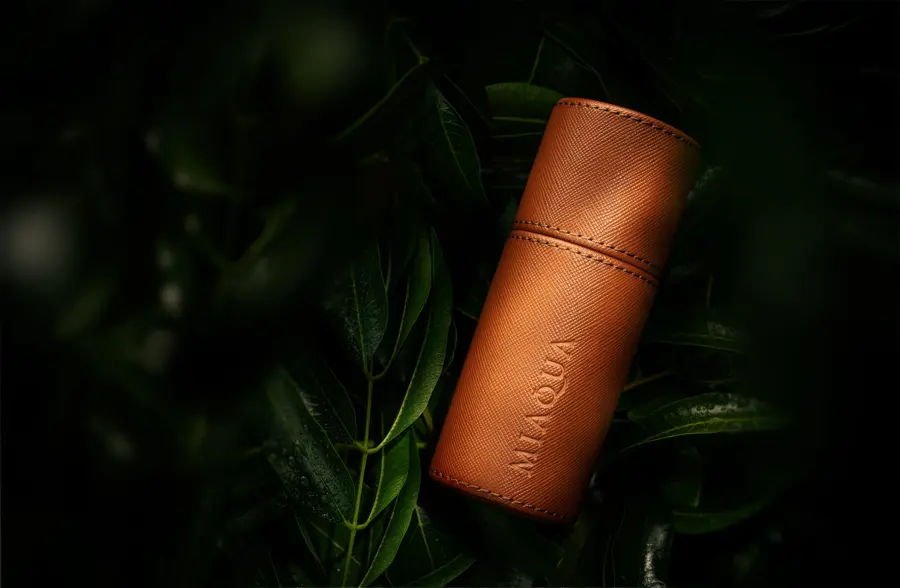 A leather wrapped bottle in dark foliage