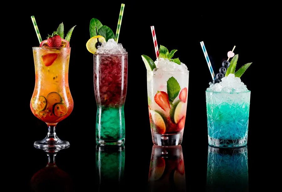 Four bright tropical cocktails on black