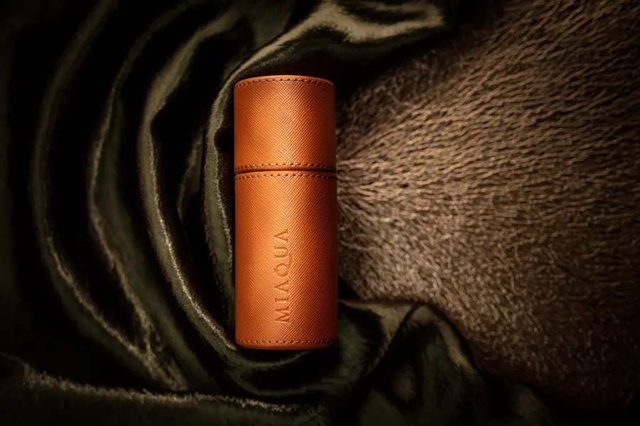 A leather wrapped bottle on dark satin and fur